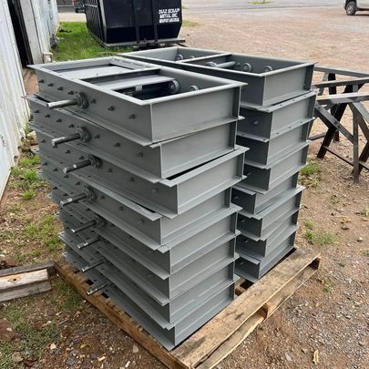 A stack of metal boxes sitting on top of a wooden pallet.