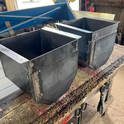 Two metal boxes are sitting on a wooden table.