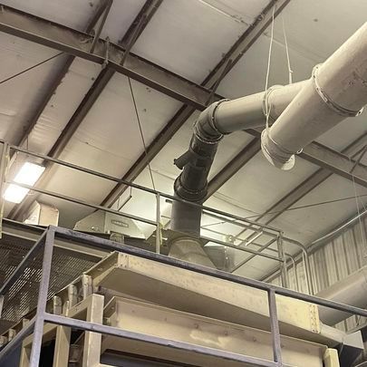 A large pipe is hanging from the ceiling of a building.