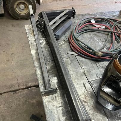 A piece of metal is sitting on a table next to a vacuum cleaner.