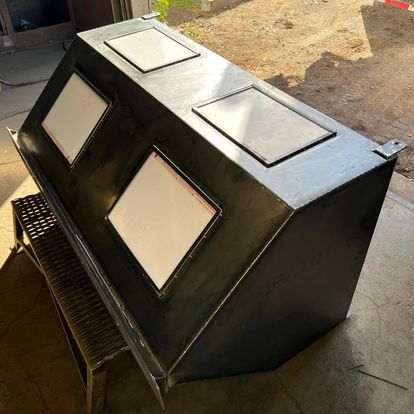 A large black box with white squares on it is sitting on the floor.