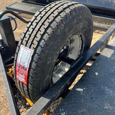 A tire is sitting on top of a trailer.