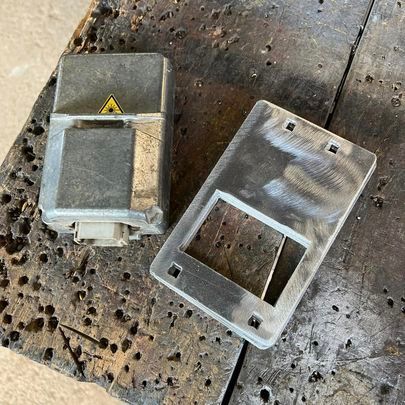 Two metal boxes are sitting on top of a wooden table.