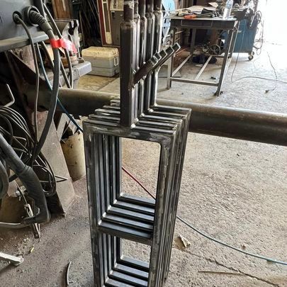 A bunch of metal pieces are stacked on top of each other in a garage.