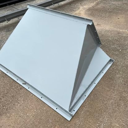 A white metal object is sitting on the ground.