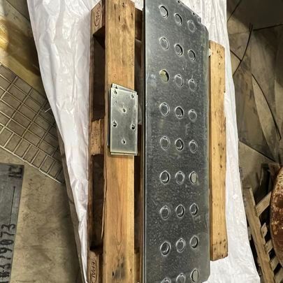 A metal plate is sitting on top of a wooden pallet.