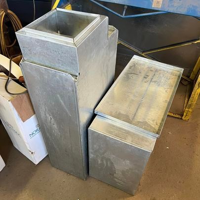 Two metal boxes are sitting next to each other on the floor.