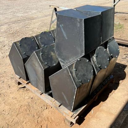 A pile of metal boxes sitting on top of a wooden pallet.