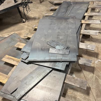 A pile of metal sheets sitting on top of wooden pallets.