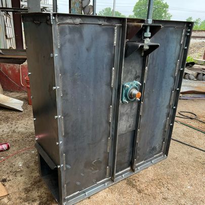 A large metal box is sitting on the ground.