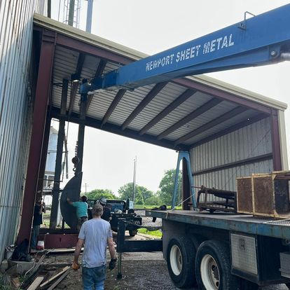 A man walking in front of a newport sheet metal truck
