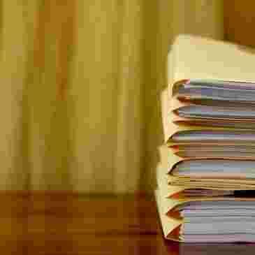 pile of legal documents grouped in folders in a desk