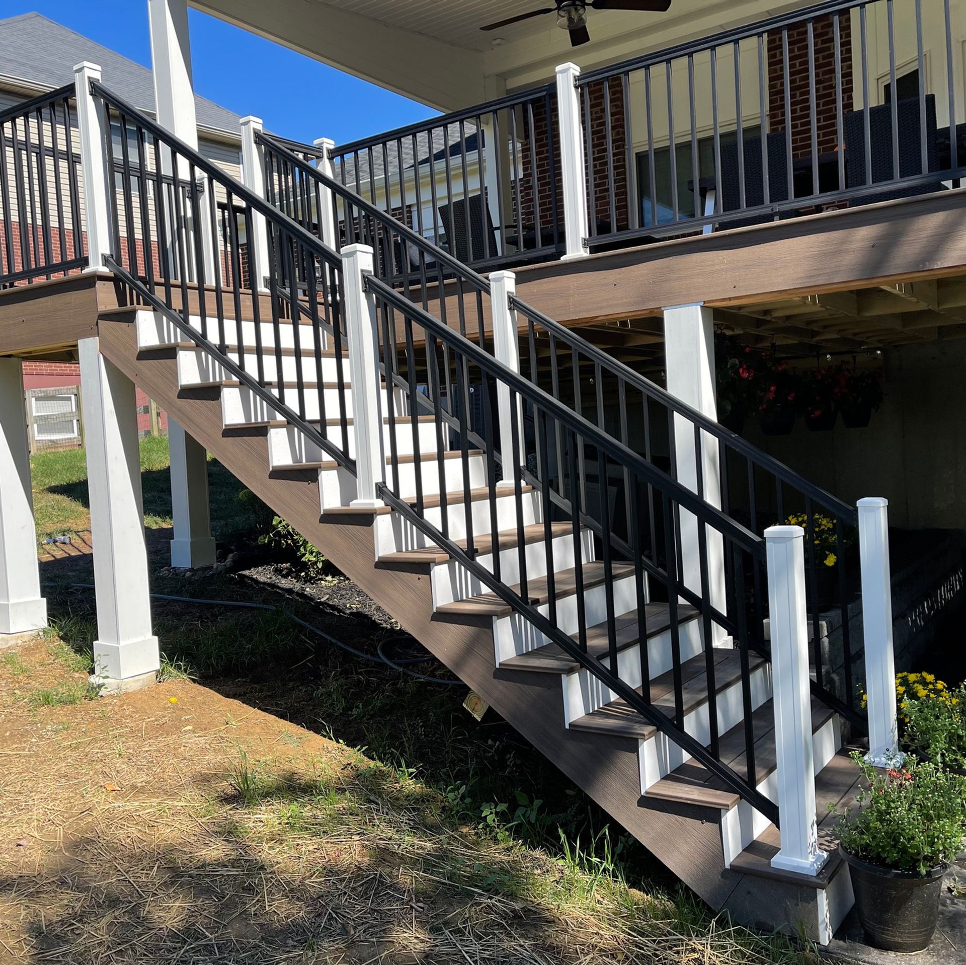 A set of stairs leading up to a deck with a black railing