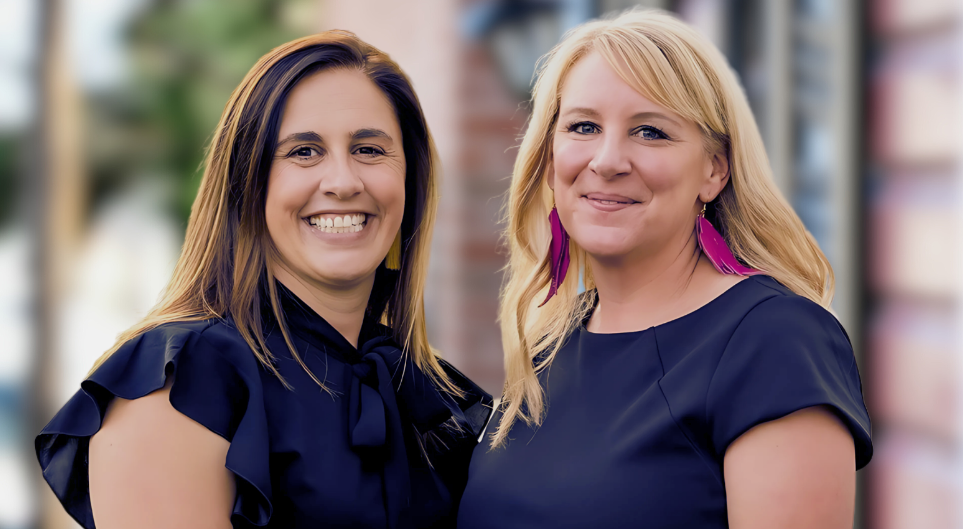 Two women are standing next to each other and smiling for the camera.