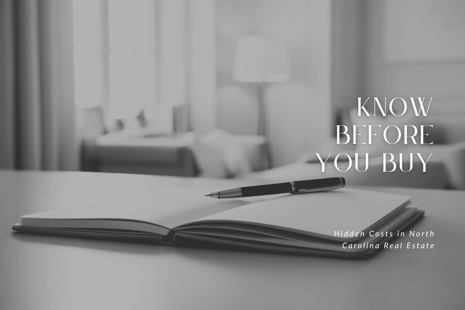 Open notebook with pen on a table, with a blurred bedroom in the background.