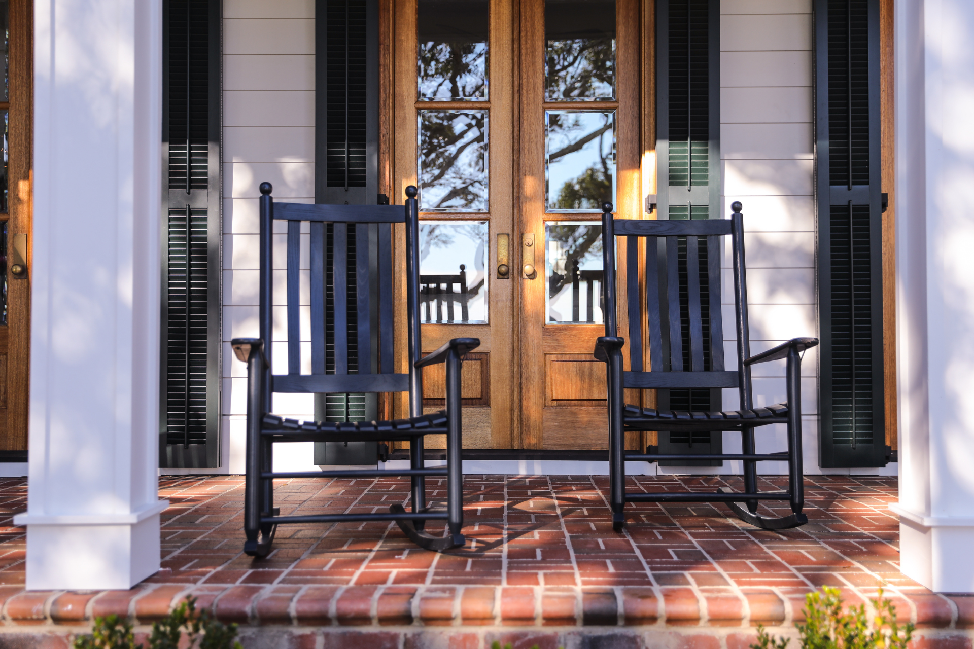 Two rocking chairs on a porch in front of a house