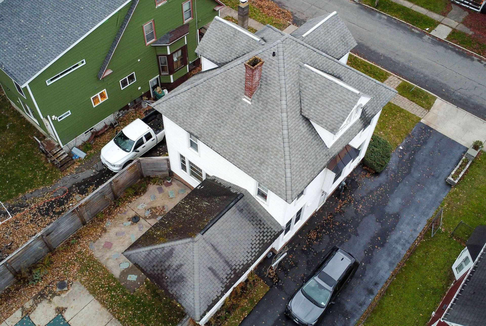 An aerial view of a house under construction with a roof being installed