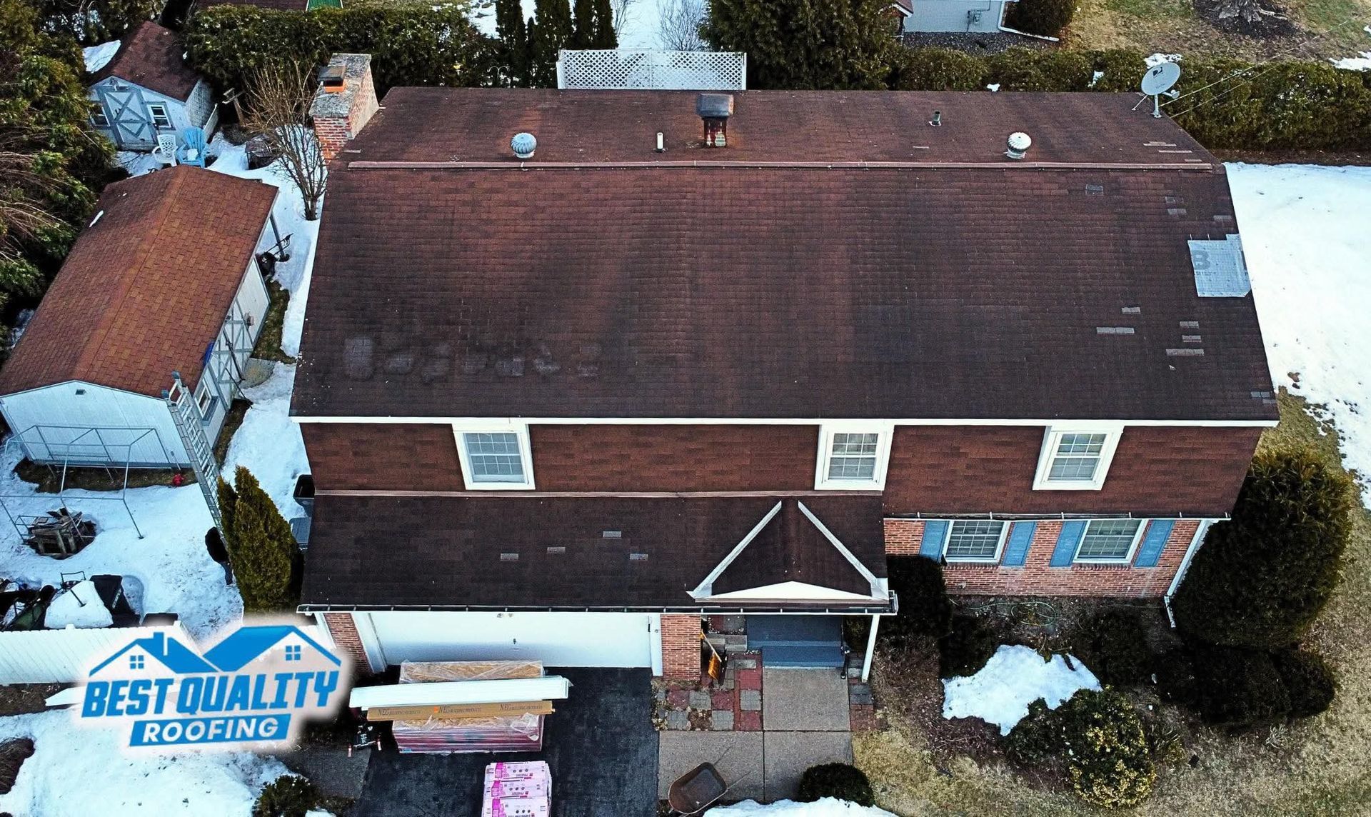 An aerial view of a house with a best quality roofing sign