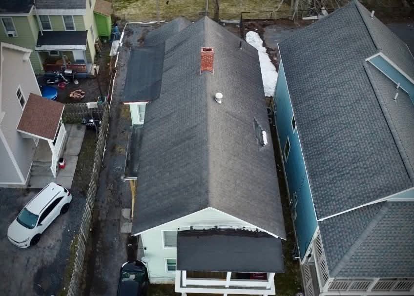 A white van is parked in front of a house