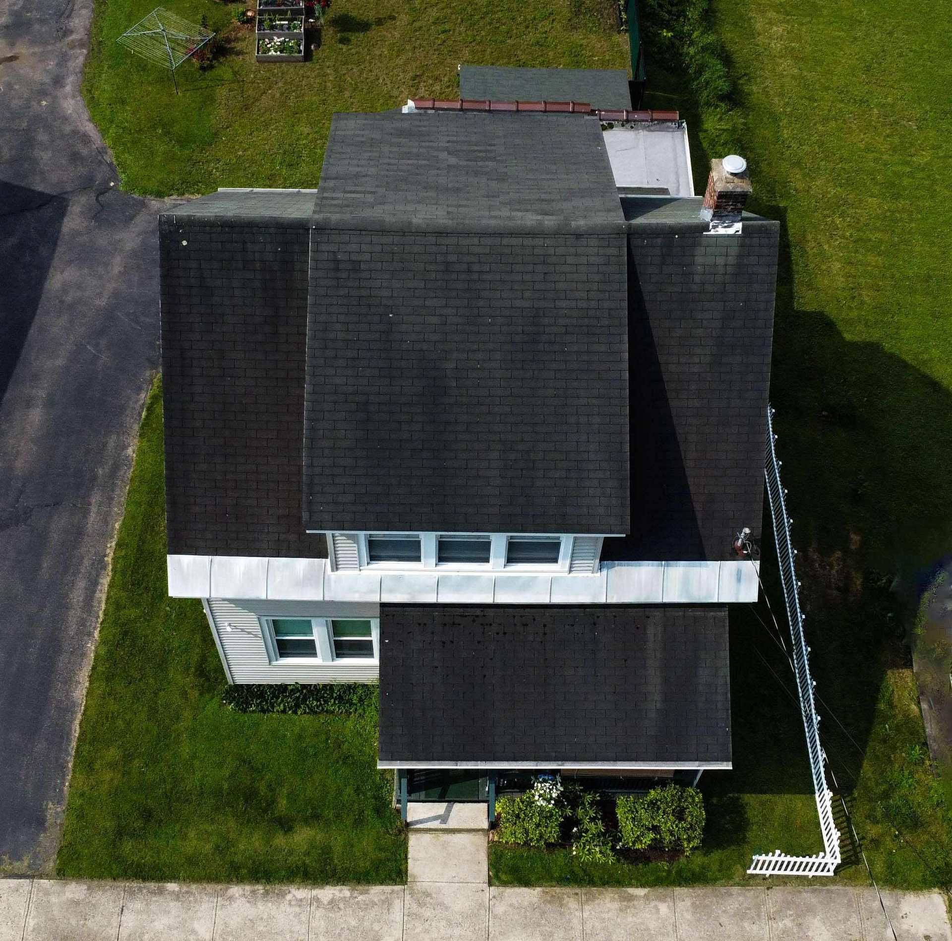 An aerial view of a house with a black roof