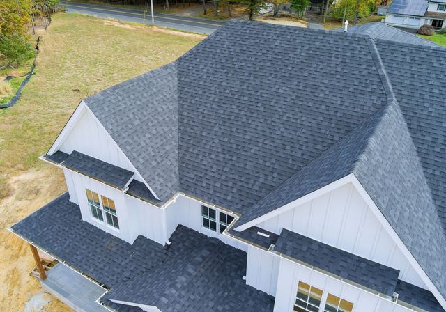 An aerial view of a house with a new black roof