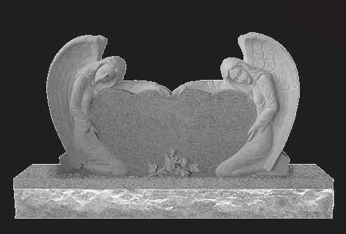 A black and white photo of a gravestone with two angels on it.