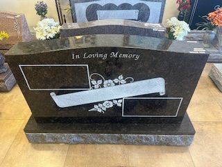 A gravestone with the words `` in loving memory '' written on it.