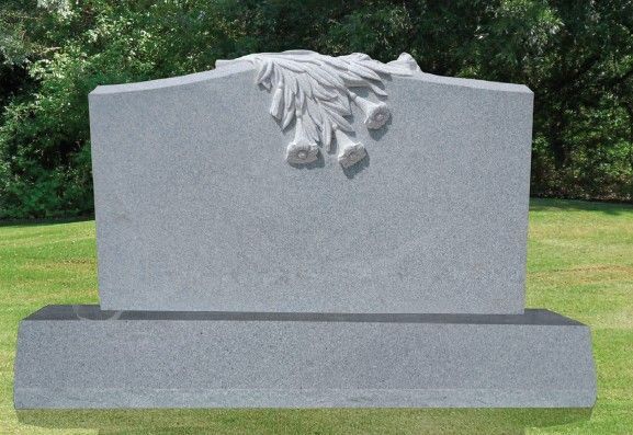 A red rose is laying on top of a grave.