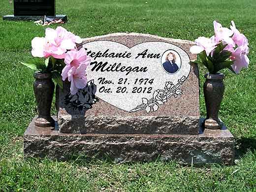 A gravestone for stephanie ann millegan with pink flowers in vases