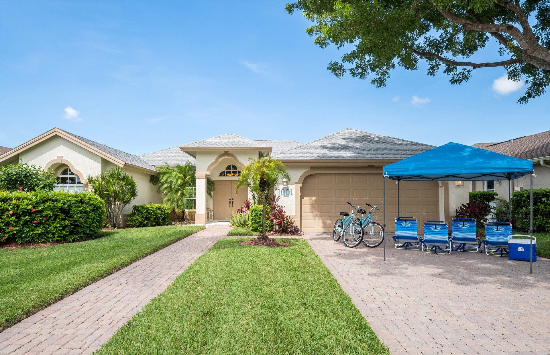 Front of Naples Lake View, Florida with bicycles, sun loungers, sunshade and cooler