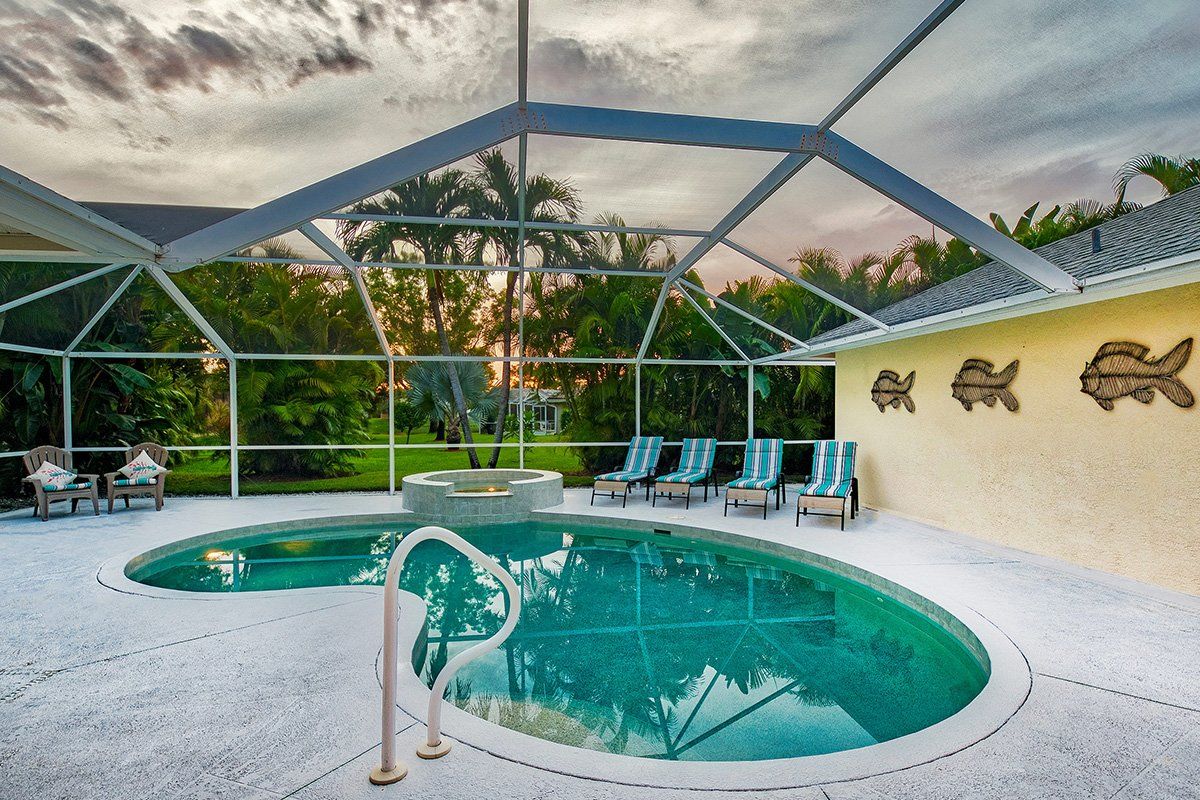 Swimming pool, spa and sun loungers at Naples Lake View, Briarwood, Florida