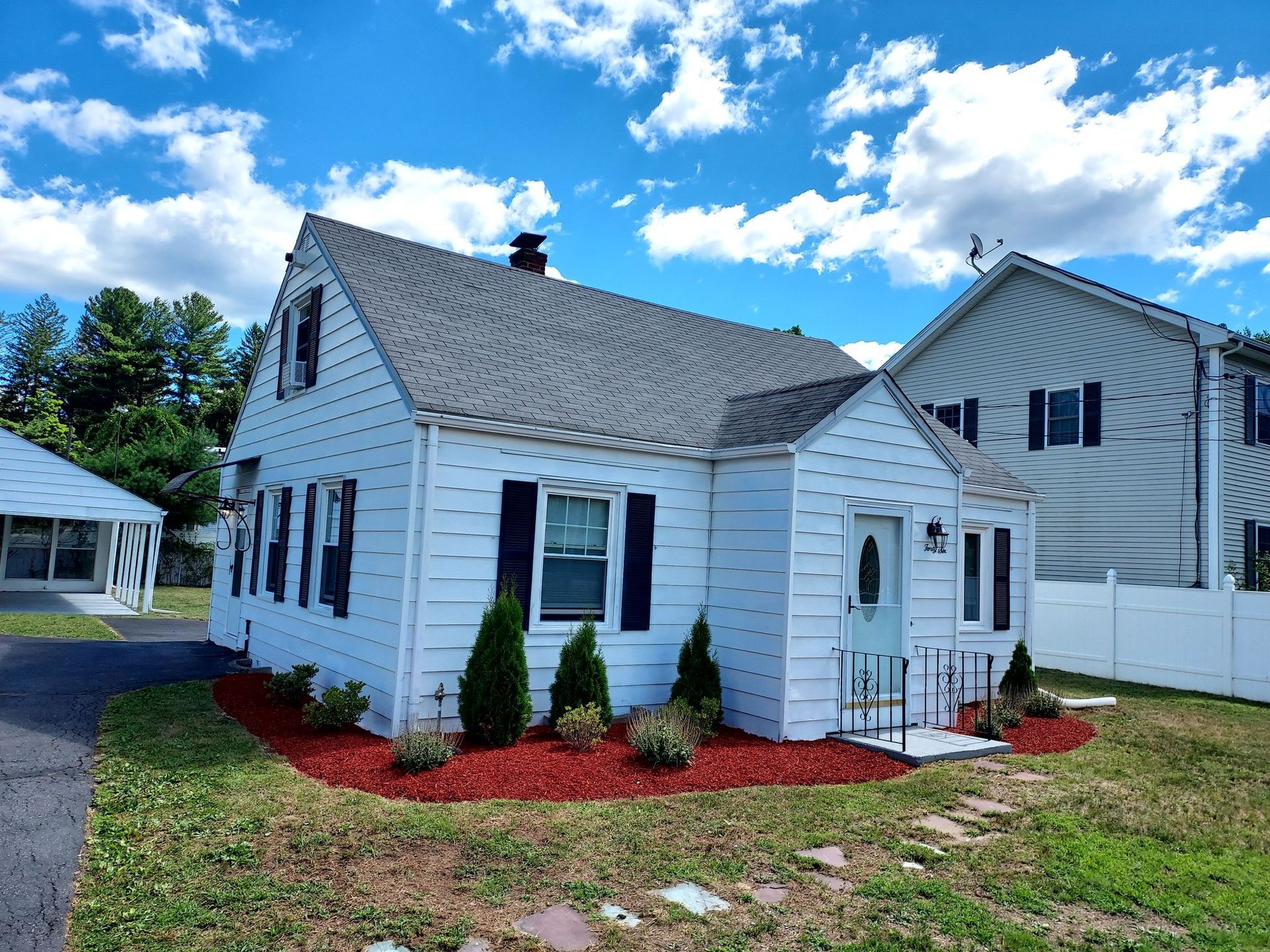 A white house with a gray roof and black shutters