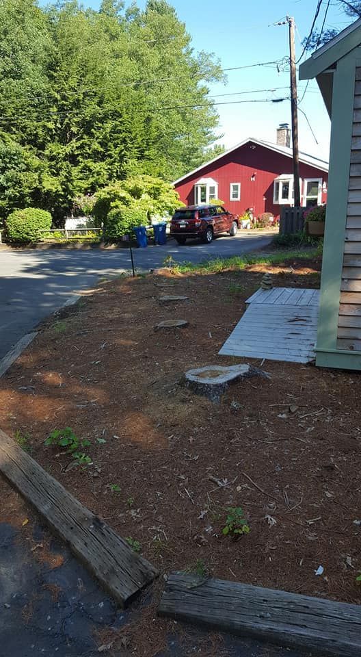 A red house is sitting on the side of the road next to a green house.