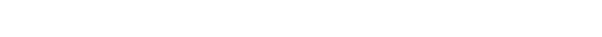 A wide, panoramic view of a snow-covered mountain range under a clear blue sky.