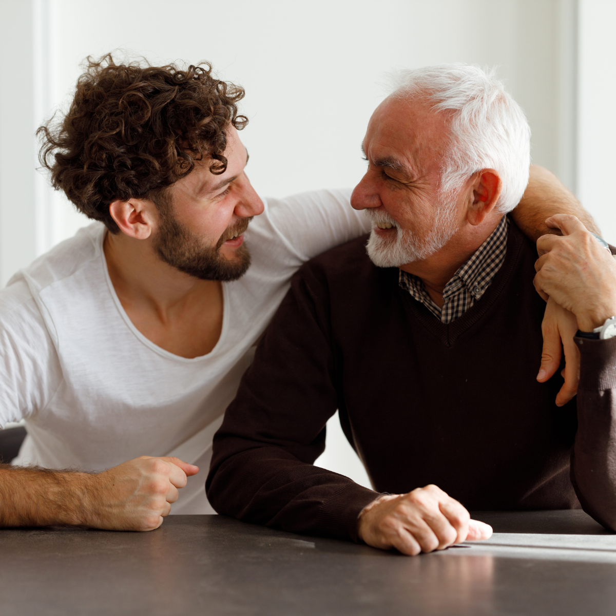 Father and son hugging and smiling.