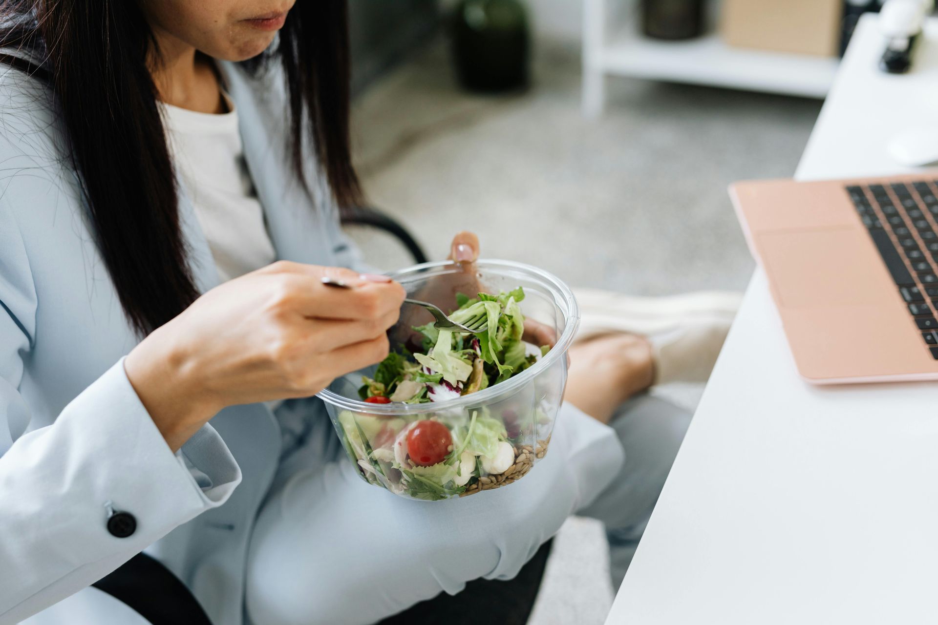 woman eating salad at her desk