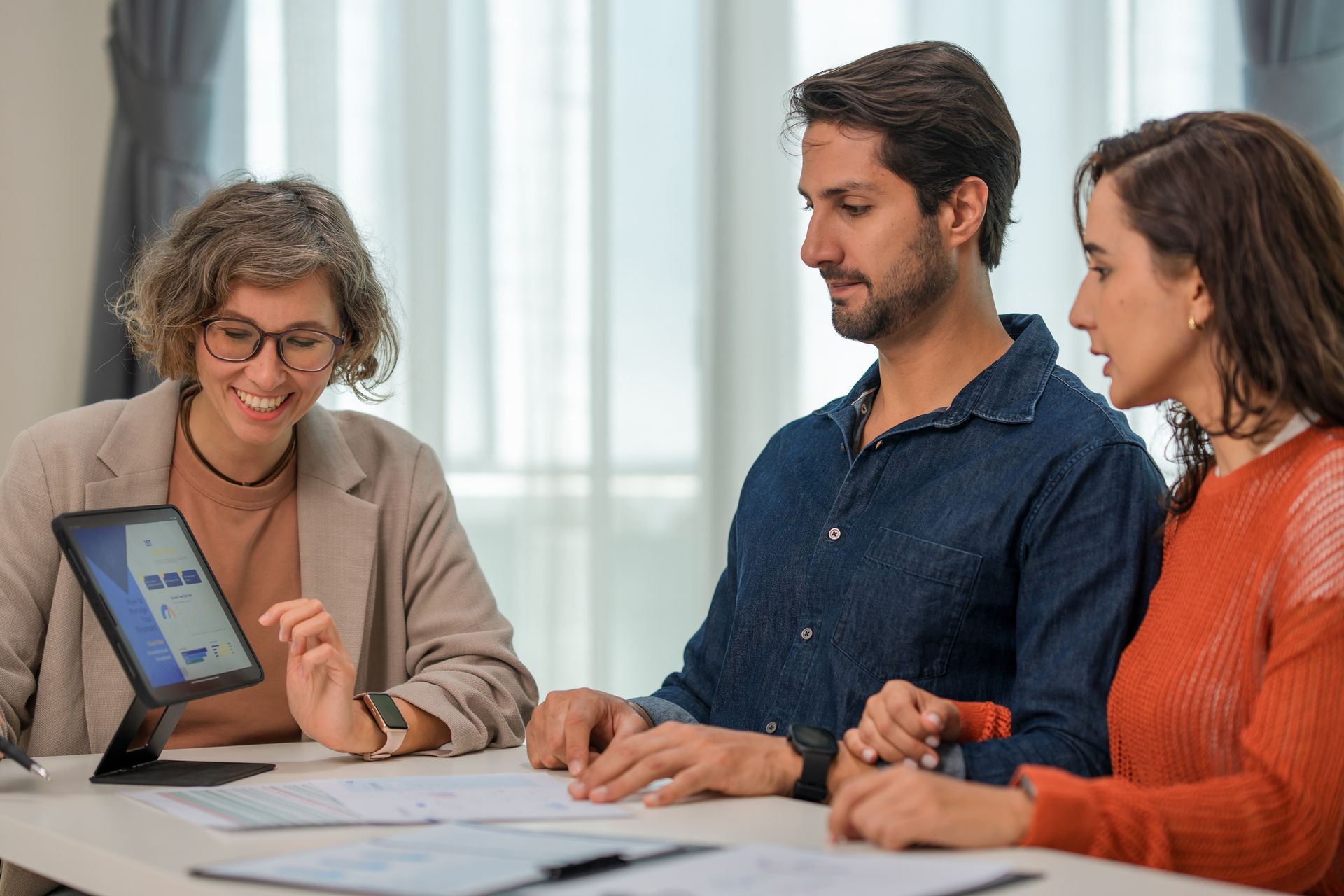 A couple is getting advice on an investment from a professional female financial advisor
