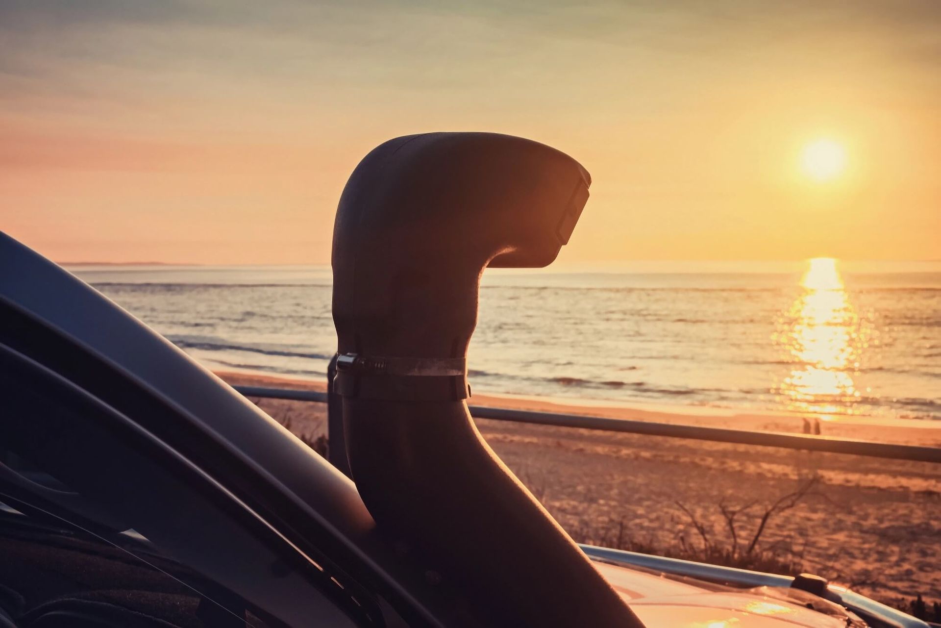 A Car with A Snorkel on The Side of It Is Parked on The Beach at Sunset — Rum City Exhaust Centre in Bundaberg Central, QLD