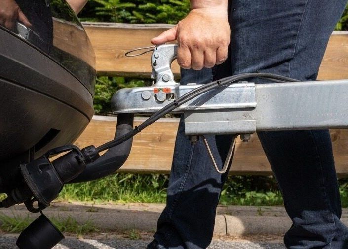 A Car Is Lifted on A Scissor Lift in A Garage — Rum City Exhaust Centre in Bundaberg Central, QLD