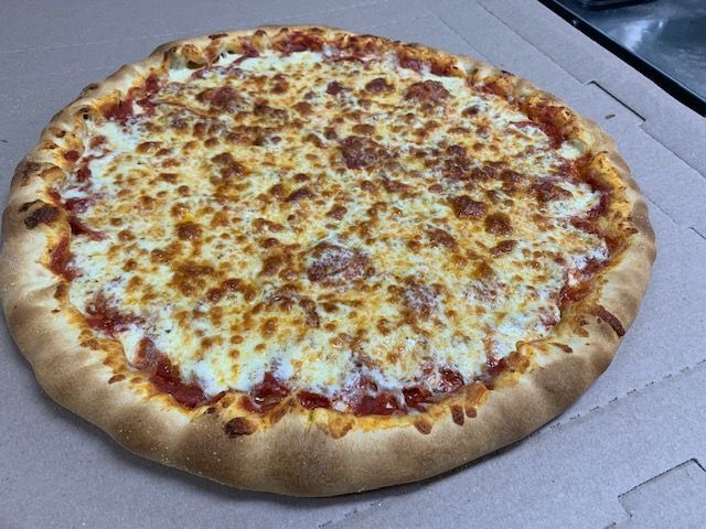 A large, round pepperoni pizza with melted cheese and red sauce in a cardboard delivery box.