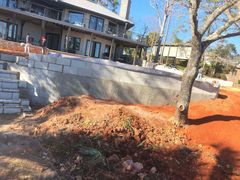 A large house is being built next to a large pile of dirt.