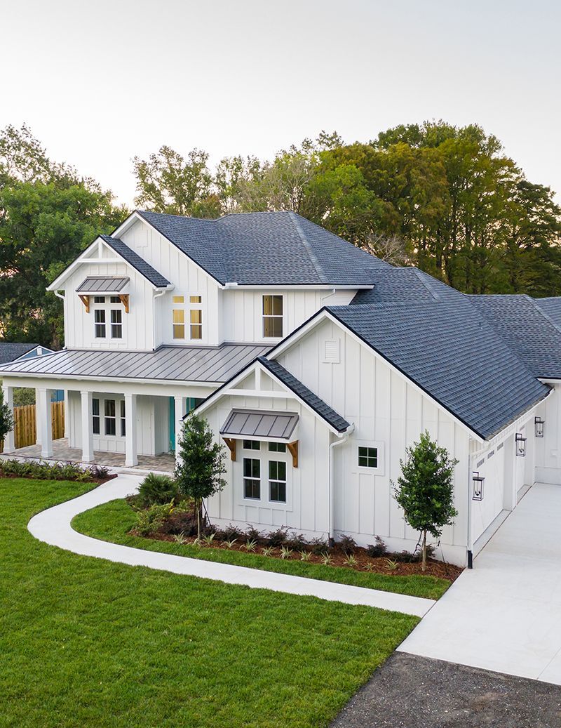 An aerial view of a large white house with a blue roof