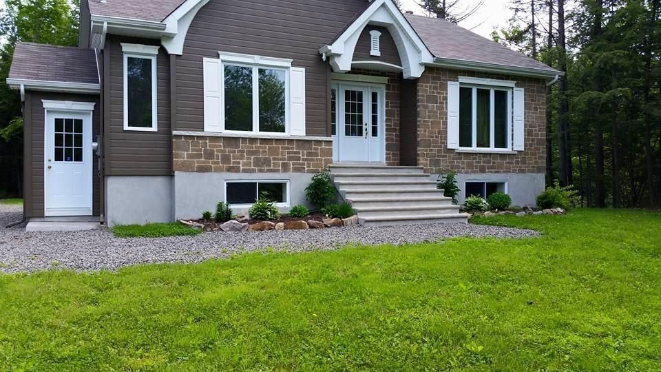 Une maison avec une grande pelouse devant elle