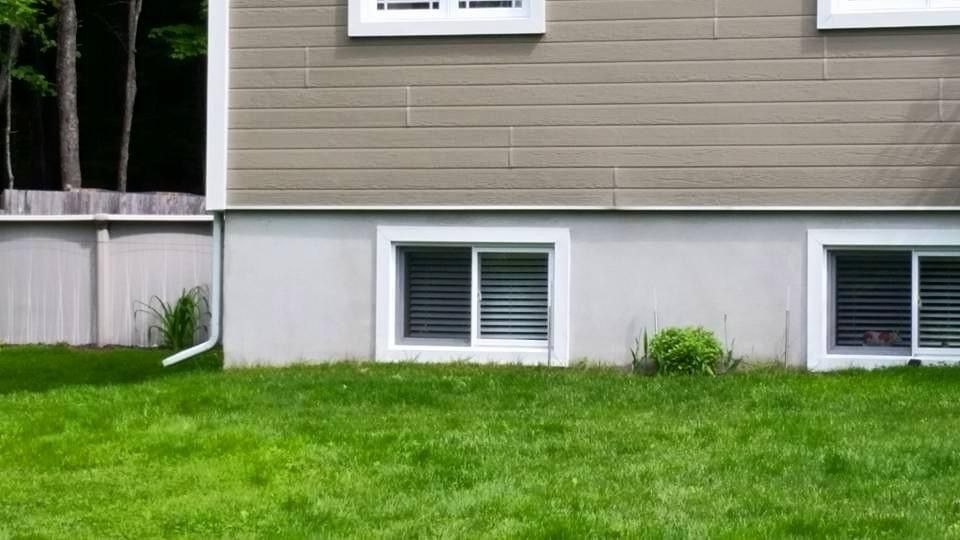 Une maison avec beaucoup de fenêtres et une pelouse devant.