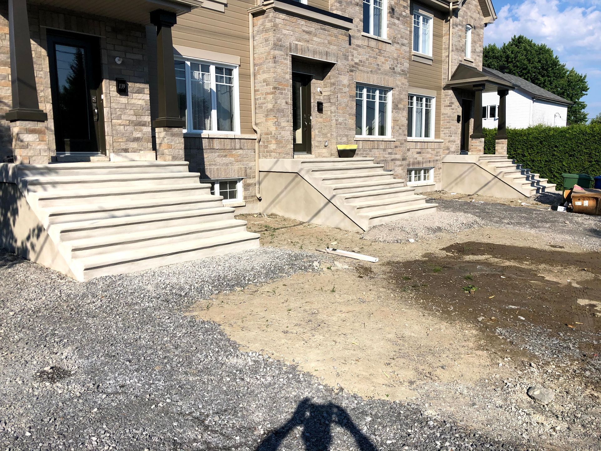 Une grande maison en pierre avec des escaliers et une allée de gravier devant elle.