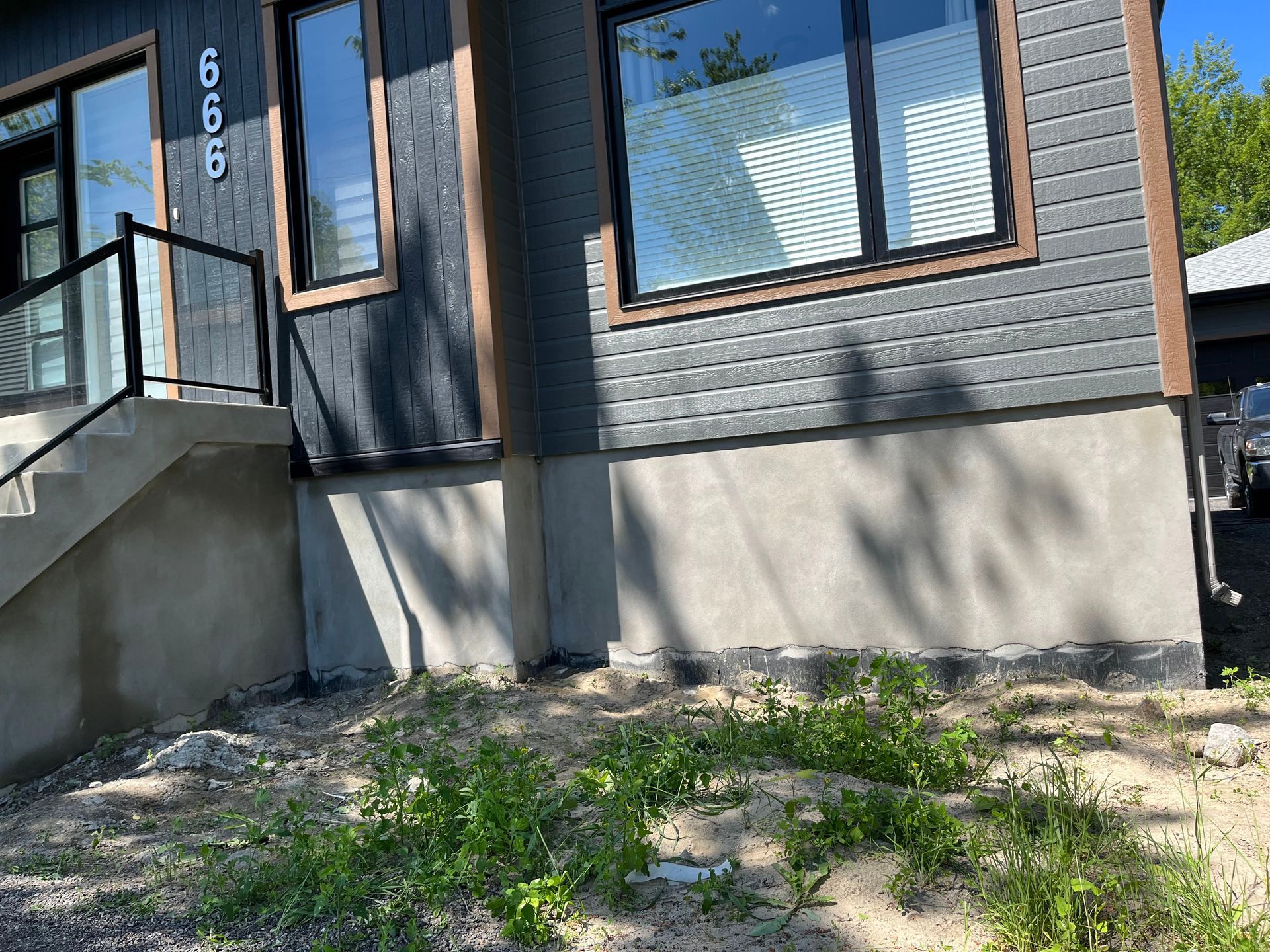 Une maison avec beaucoup de fenêtres et d'escaliers est située au sommet d'une colline de terre.