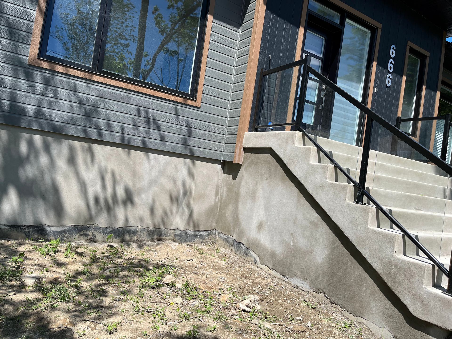 Un ensemble d'escaliers menant à un bâtiment avec une rampe en métal.
