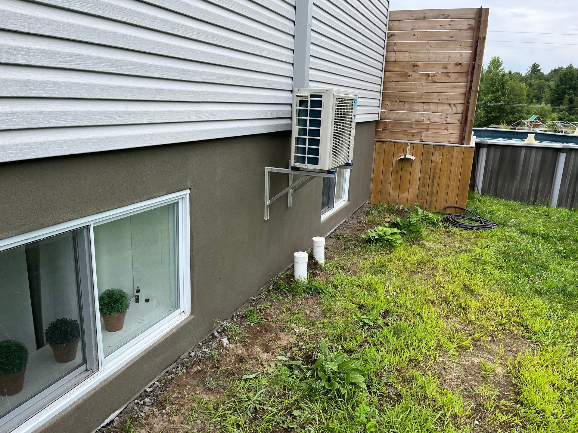 Une maison avec une fenêtre et un climatiseur sur le côté.
