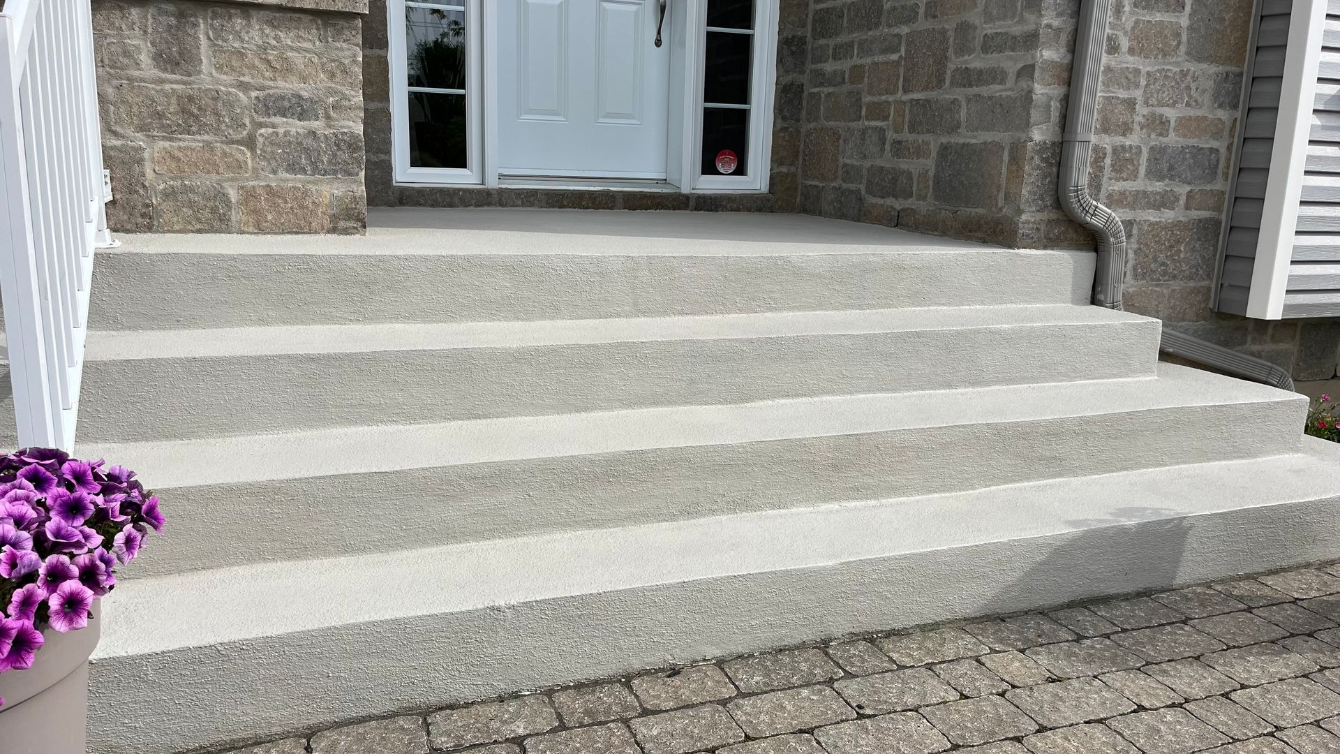 Une plante en pot est posée sur les marches d'une maison.