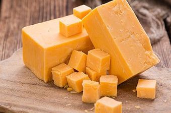 a close up of a piece of cheese on a cutting board .